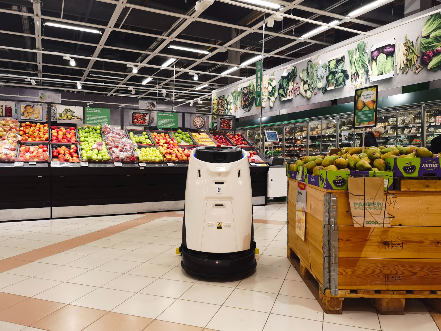 Commercial robotic sweeper cleaning grocery store floor
